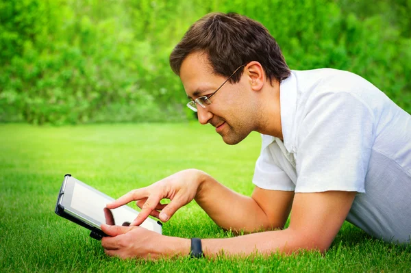 Взрослый мужчина работает с планшетным компьютером на открытом воздухе в парке — стоковое фото