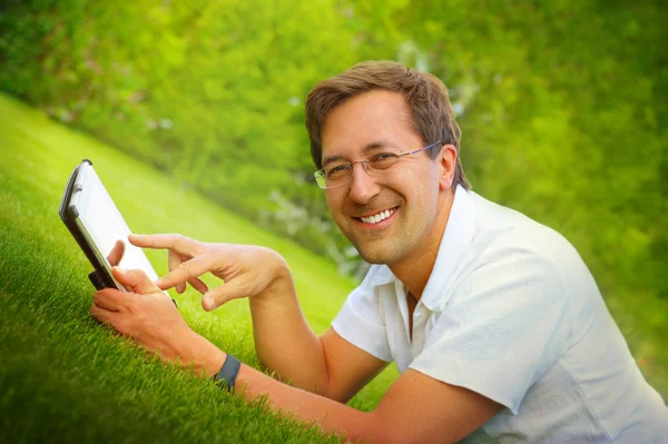 Adult man working with tablet computer outdoor in park — Stock Photo, Image