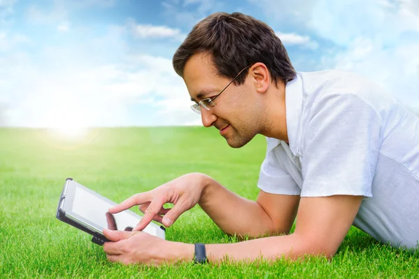 Volwassen man op zomer park rust op weekend met behulp van zijn tablet com — Stockfoto