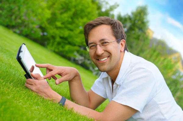 Erwachsener Mann im Sommerpark ruht sich am Wochenende mit Tablet aus — Stockfoto
