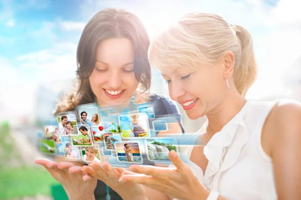 Två kvinnor sitter på park och använda virtuella gränssnitt att titta på v — Stockfoto