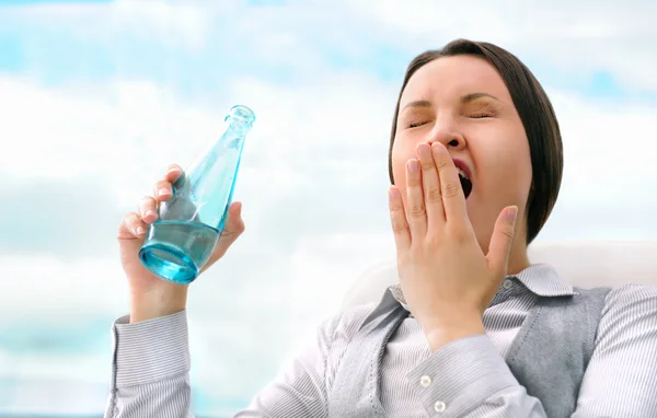 Портрет красивой деловой женщины, пьющей воду и зевающей — стоковое фото