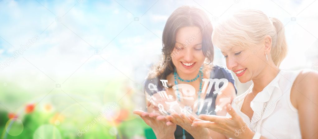 Two women mother and daughter sitting at summer park and having