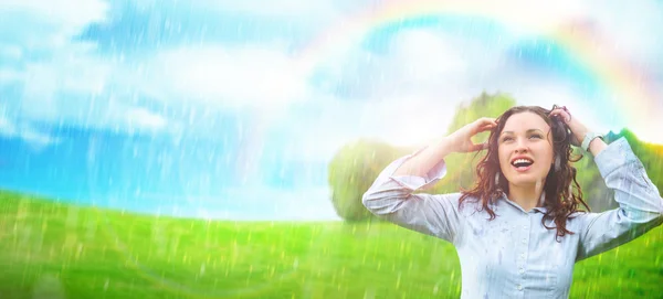 Молодая женщина на улице под дождем против красивых пейзажей — стоковое фото
