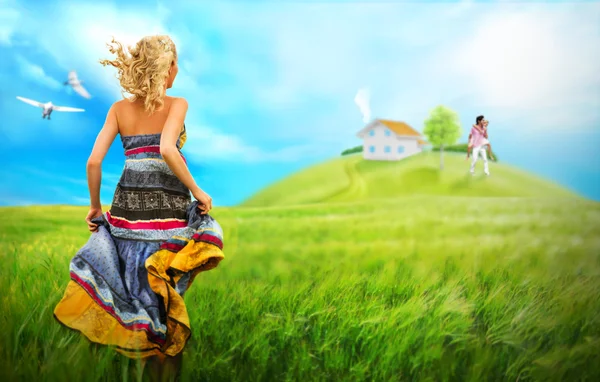 Giovane donna che corre attraverso il campo a casa e la famiglia del suo sogno — Foto Stock