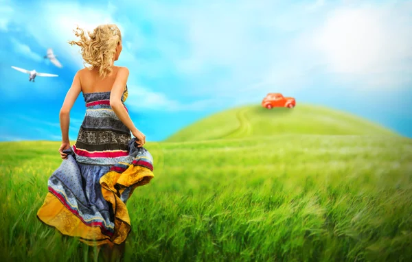 Junge Frau läuft über Feld zum Auto auf einem Hügel — Stockfoto