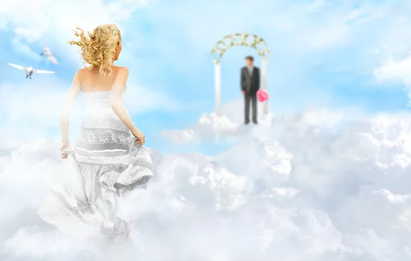 Молодая невеста бежит к жениху, чтобы алтарь через облака — стоковое фото