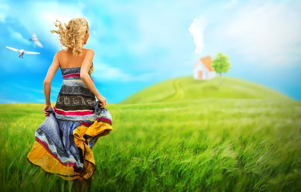 Junge Frau in elegantem Kleid läuft zum Haus ihres Traums — Stockfoto