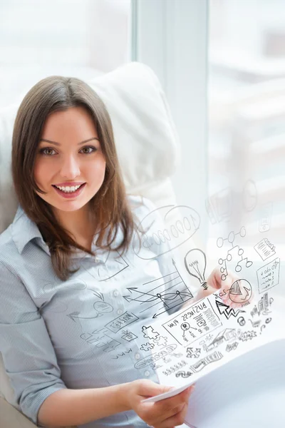 Jonge mooie vrouwelijke ondernemer zittend op een stoel en maken van notities voor haar businessplan — Stockfoto