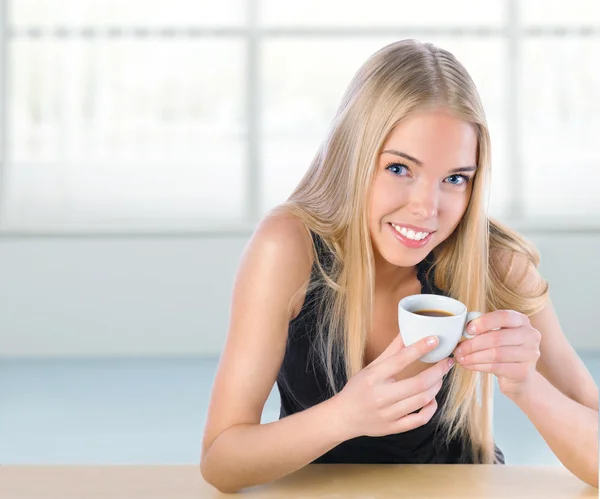 Jonge mooie vrouw koffie drinken op haar werkplek — Stockfoto