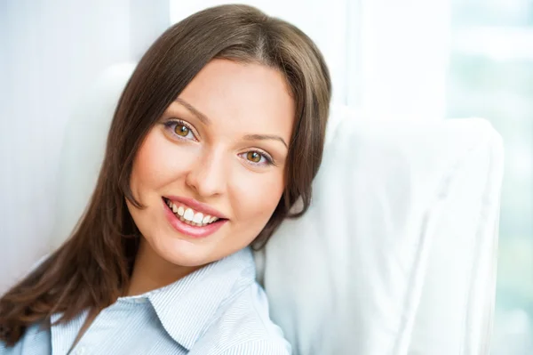 Closeup portret van schattige jonge zakenvrouw glimlachen terwijl sitt — Stockfoto