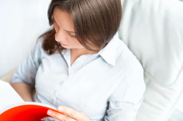 Portrait of a sensual young woman reading a novel while sitting — Stock Photo, Image