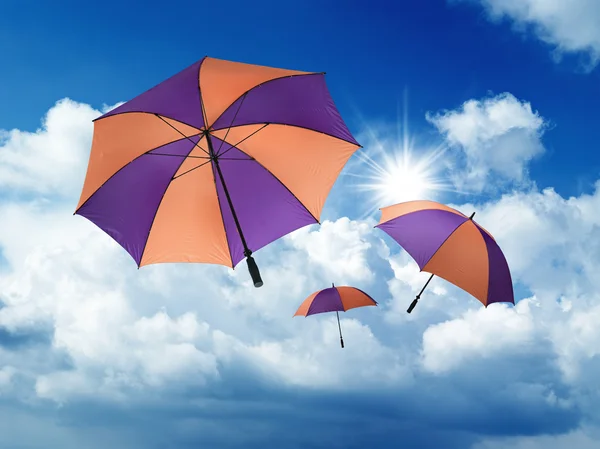 Umbrella'nın beyaz kümülüs bulutları ile mavi gökten düşen — Stok fotoğraf
