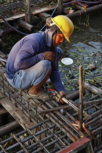Thailand, Bangkok, a thai welder working at the contruction of a bridge on the Chao Phraya river — Stock Photo, Image