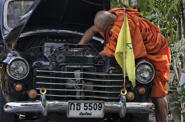 タイ、チェンマイ、仏教の僧侶は彼の古い車のエンジンを修正しようとしています。 — ストック写真