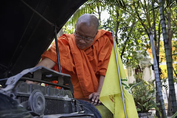 泰国，清迈，一名佛教僧人正在试图修复他的旧车引擎 — 图库照片
