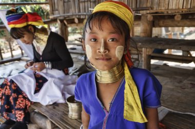 Thailand, Chang Mai, Karen Long Neck hill tribe village (Kayan Lahwi), young girl and her mother in traditional costumes. Women put brass rings on their neck when they are 5 or 6 years old and increas clipart