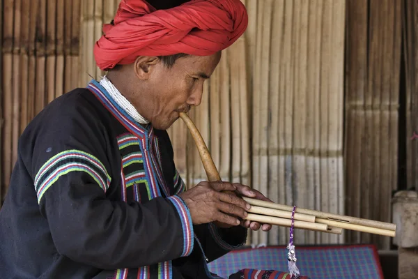 Thaïlande, Chiang Mai, Karen Long Neck hill tribe village (Kayan Lahwi), Karen homme en costumes traditionnels jouant d'une flûte — Photo