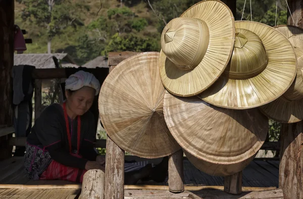 Thailand, chiang mai, karen long neck hill tribe village (kayan lahwi), eine karen frau in traditionellen trachten und orientalischen hüten zum verkauf — Stockfoto