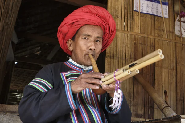 Tailandia, Chiang Mai, Karen Long Neck aldea de la tribu de la colina (Kayan Lahwi), Karen hombre en trajes tradicionales tocando una flauta — Foto de Stock