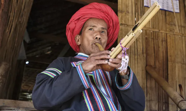 Thailandia, Chiang Mai, Karen Long Neck villaggio tribù collinare (Kayan Lahwi), Karen uomo in costumi tradizionali suonare un flauto — Foto Stock