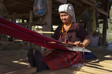 Tayland, chiang mai, karen uzun boyunlu tepe kabile Köyü (kayan lahwi), karen kadın geleneksel kostümleri bir halı yapıyor