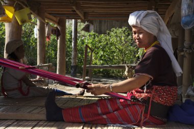 Tayland, chiang mai, karen uzun boyunlu tepe kabile Köyü (kayan lahwi), karen kadın geleneksel kostümleri bir halı yapıyor