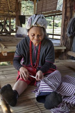 Tayland, chiang mai, karen uzun boyunlu tepe kabile Köyü (kayan lahwi), karen kadın geleneksel kostümleri bir halı yapıyor