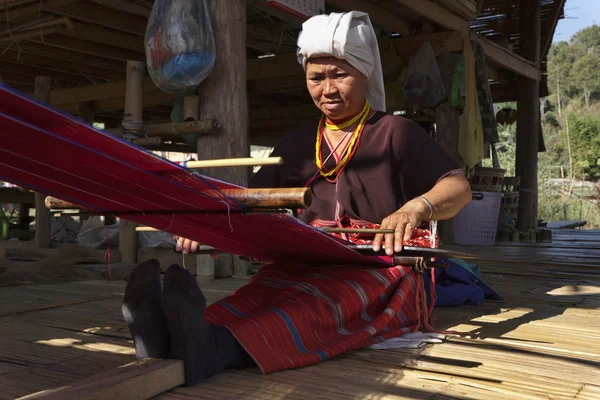 Thailand, chiang mai, karen lång hals backen stam byn (kayan lahwi), karen kvinna i traditionella dräkter är att göra en matta — Stockfoto