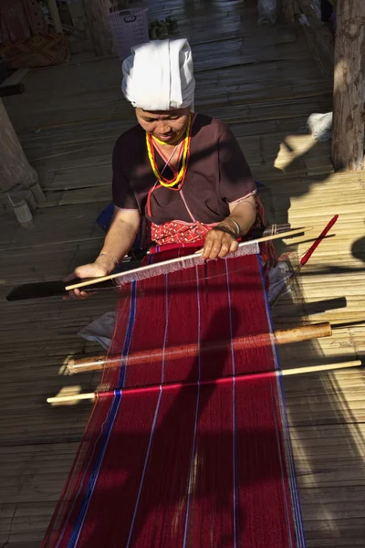 Thailand, chiang mai, karen long neck hill tribe village (kayan lahwi), eine karen frau in traditionellen trachten macht einen teppich — Stockfoto