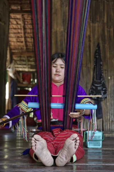 Thailand, Chiang Mai, Karen Long Neck hill tribe village (Kayan Lahwi), Karen woman in traditional costumes is making a carpet — Stock Photo, Image