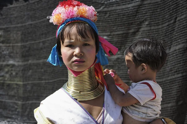 Таиланд, Чанг Май, деревня племени Каян Лахви (Karen Long Neck hill village, Kayan Lahwi), ребенок с длинной шеей и её мать в традиционных костюмах. Женщины надевают медные кольца на шею, когда им 5 или 6 лет и в — стоковое фото