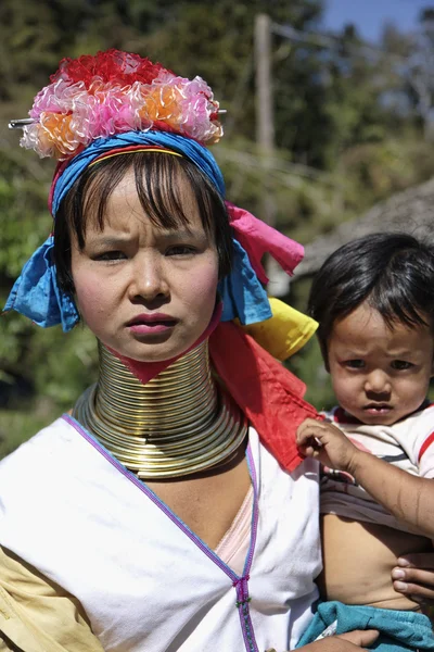 Thailand, Chang Mai, Karen Long Neck hill tribe village (Kayan Lahwi), Long Neck child and her mother in traditional costumes. Women put brass rings on their neck when they are 5 or 6 years old and in — Stock Photo, Image