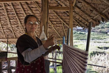 Tayland, chiang mai, karen uzun boyunlu tepe kabile Köyü (kayan lahwi), karen kadın geleneksel kostümleri bir halı yapıyor