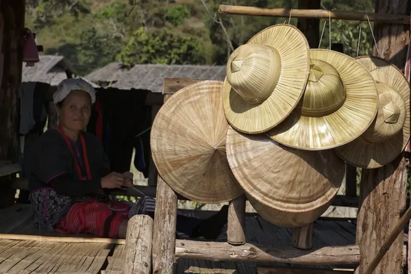 Thailand, chiang mai, karen long neck hill tribe village (kayan lahwi), eine karen frau in traditionellen trachten und orientalischen hüten zum verkauf — Stockfoto