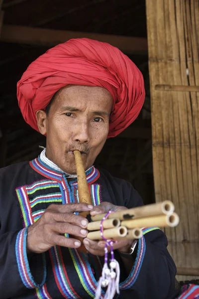 Tailândia, Chiang Mai, Karen Long Neck aldeia tribo colina (Kayan Lahwi), Karen homem em trajes tradicionais tocando uma flauta — Fotografia de Stock