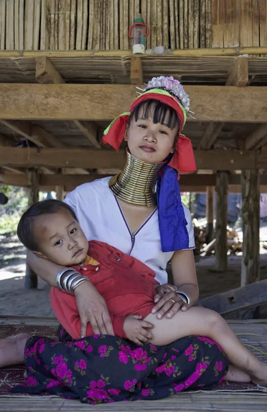 Thailand, Chang Mai, Karen Long Neck hill tribe village (Kayan Lahwi), Long Neck child and his mother in traditional costumes. Women put brass rings on their neck when they are 5 or 6 years old and in — Stock Photo, Image