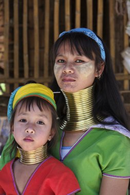 Thailand, Chiang Mai, Karen Long Neck hill tribe village (Baan Tong Lhoung), Long Neck woman with her child in traditional costumes. Women put brass rings on their neck when they are 5 or 6 years old clipart