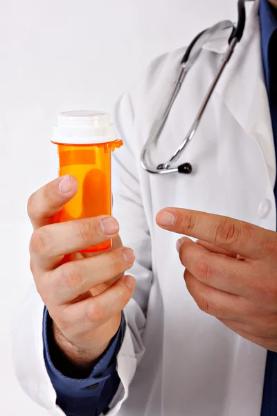 Lekarz ręką wskazując na pusty tabletek bottole — Zdjęcie stockowe