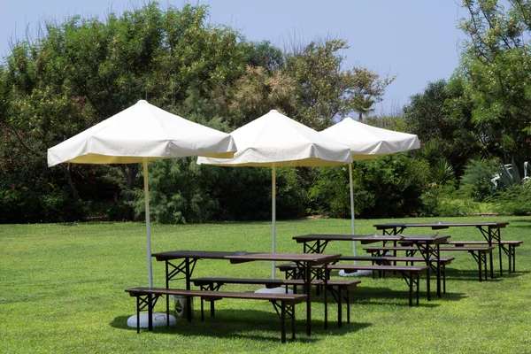 Tavoli e panche per rilassarsi sotto gli ombrelloni Foto Stock Royalty Free