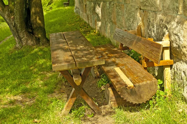 Park bench at an old antique abbey wall — Stock Photo, Image