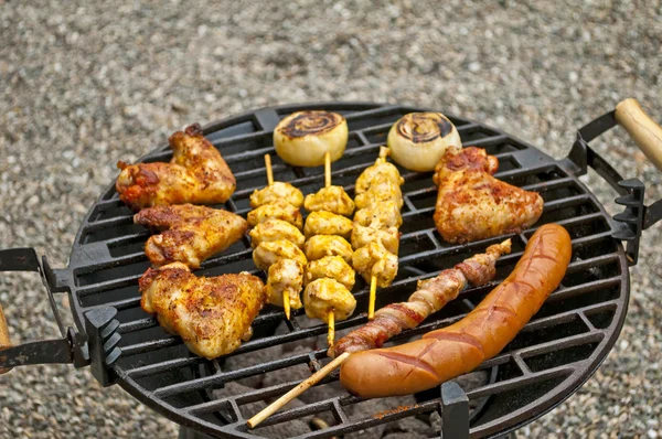 Grill med kycklingvingar, bratwurst, kött spett och skinka — Stockfoto