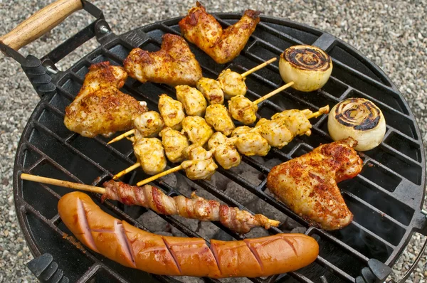 Churrasco com asas de frango, Bratwurst, espeto de carne e presunto — Fotografia de Stock
