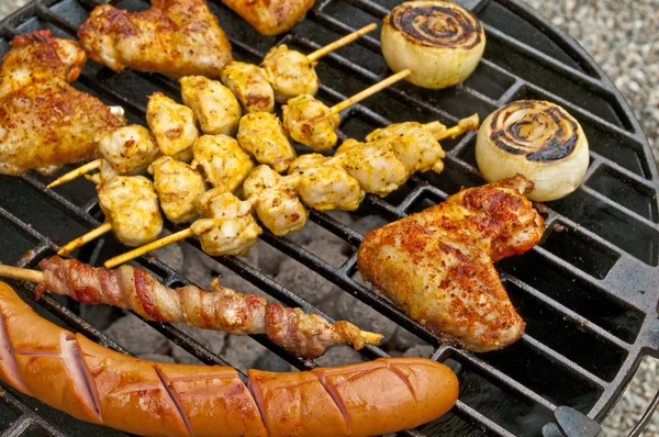 Grill med kycklingvingar, bratwurst, kött spett och skinka — Stockfoto