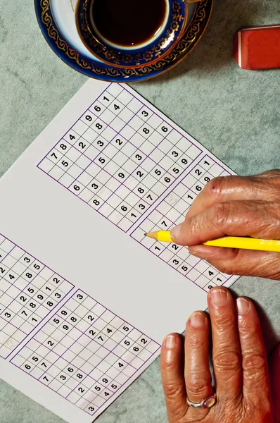 Pensioner with sudoku — Stock Photo, Image