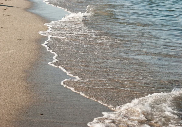 Parlak deniz dalgaları üzerinde plaj kum — Stok fotoğraf