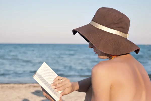 Kobieta czyta książkę na plaży — Zdjęcie stockowe