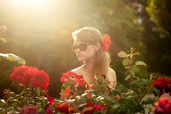 年轻女子在花卉园嗅到的红玫瑰 #1 — 图库照片
