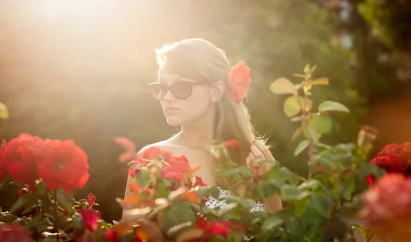 年轻女子在花卉园嗅到的红玫瑰 #2 — 图库照片