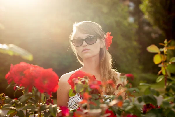 年轻女子在花卉园嗅到的红玫瑰 #3 — 图库照片